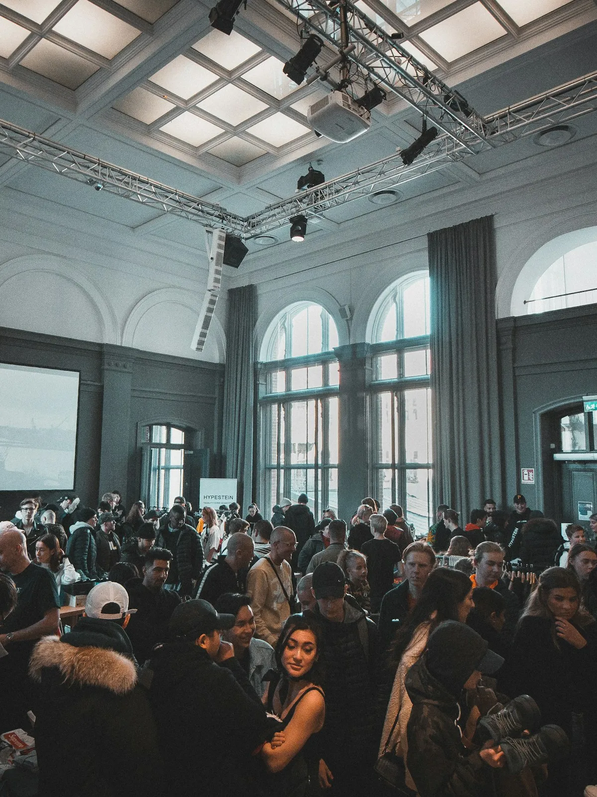 A large audience seated at a conference in a bright hall