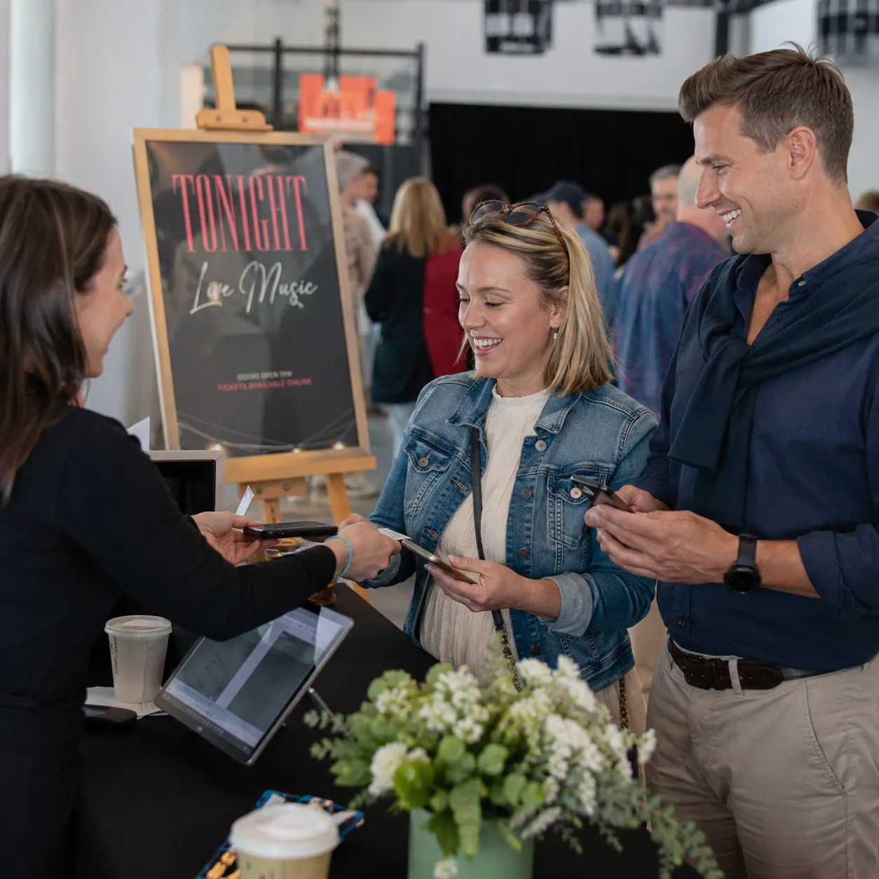 Attendees buying tickets at an event ticket desk