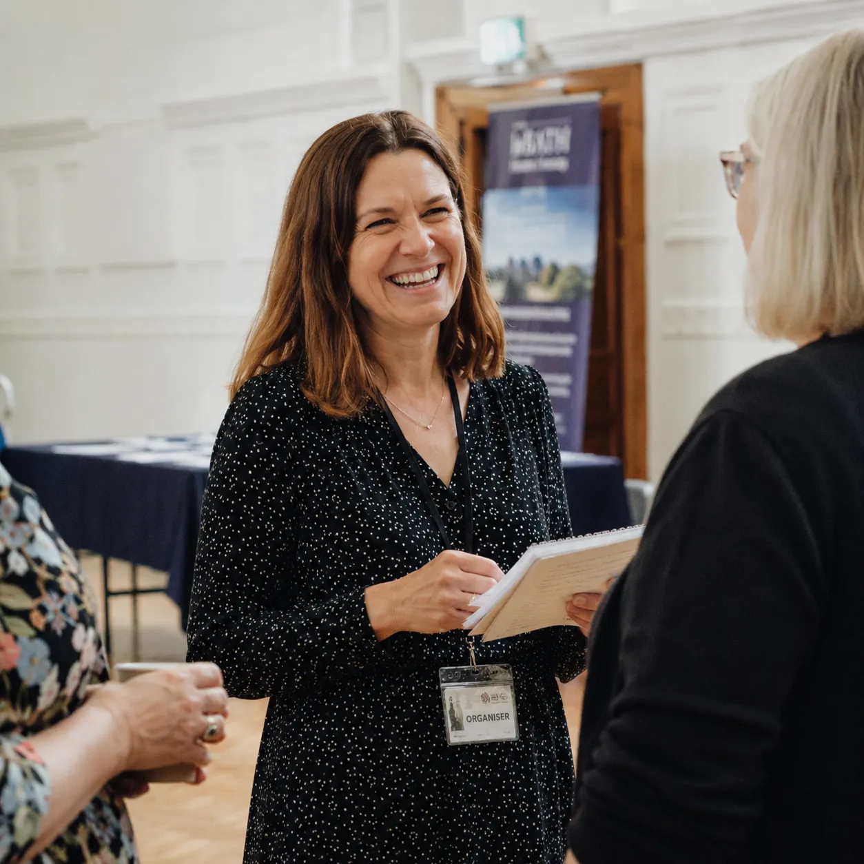 An event organiser welcoming guests at a small gathering