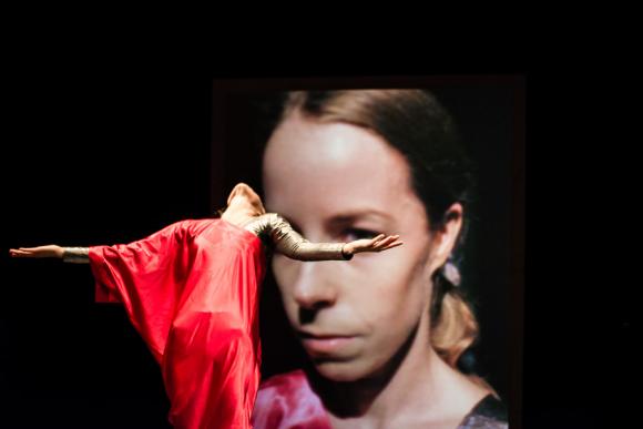 Girl in red dancing in front of screen