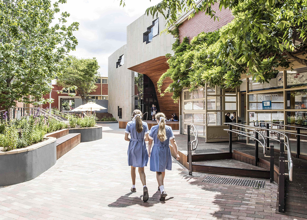 Two girls walking through the grounds at school