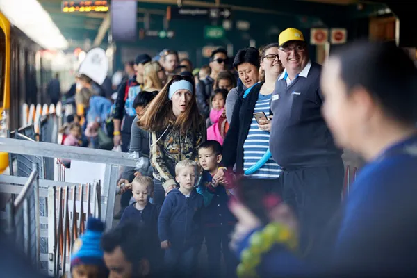 Pre-school children and parents learning rail safety beside a train
