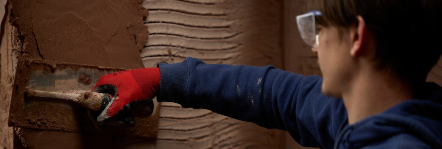 This image depicts a Leeds college of Building student in a plastering workshop