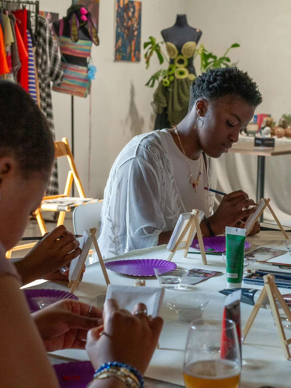 People painting at a table in an art class